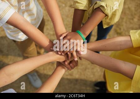 Draufsicht Nahaufnahme bei multiethnischen Gruppen von Kindern, die sich im Kreis im Freien, im Konzept der Freundschaft und Einheit, die Hände stapeln Stockfoto