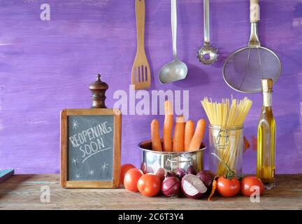 Restaurant kündigt Wiedereröffnung nach der Corona-Sperre, Kochen, kulinarisches Konzept auf Tafel. Küchenutensilien und Bio-Lebensmittel Zutaten. Stockfoto