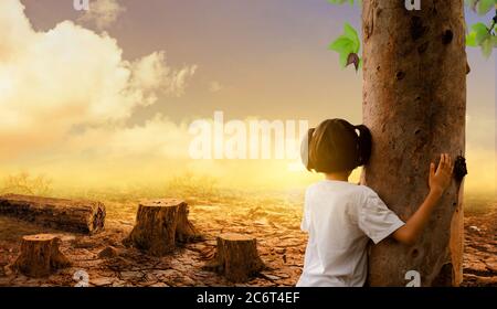 Mädchen umarmt einen Baum auf der geknackten Erde und toten Bäumen Hintergrund. Globale Erwärmung. Stockfoto