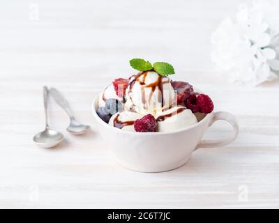 Kugeln aus Vanille-Eis in Becher mit Himbeere und Heidelbeeren Stockfoto