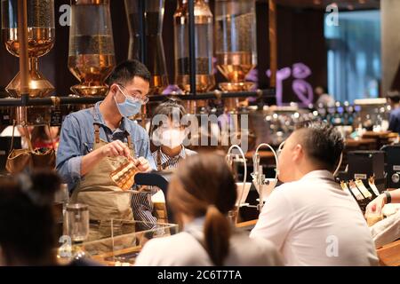 Nahaufnahme Angestellte tragen Gesichtsmaske, um covid-19 Coronavirus zu vermeiden, arbeiten in Café Stockfoto