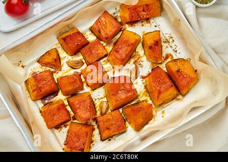 Tablett mit gerösteten Stücken süßen Kürbisses mit Honig und Gewürzen, Draufsicht Stockfoto