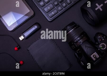 Draufsicht Arbeitsbereich Fotograf mit Digitalkamera, Rechner, USB-Laufwerk und Zubehör auf schwarzem Tisch Hintergrund mit Kopierer Platz. Moderne schwarze Acce Stockfoto