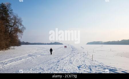 Menschen, die auf einer Eisstraße gehen, pflügten zum See Eis im Winter, Finnland Stockfoto