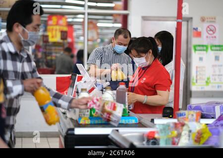 Arbeiten Kassierer im Carrefour Supermarkt, trägt Gesichtsmaske covid-19 Coronavirus zu vermeiden Stockfoto