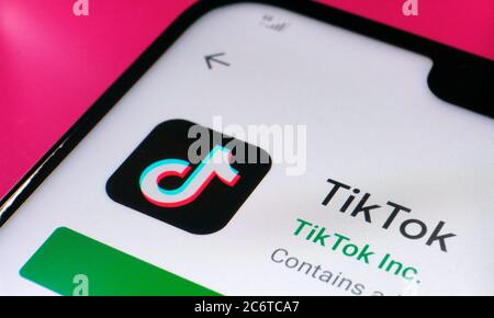 Stone / Großbritannien - Juli 12 2020: TikTok App in Google Play auf der Ecke des Smartphones auf rosa Oberfläche platziert gesehen.