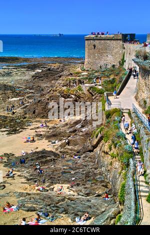 Saint-Malo, Bretagne, Frankreich. Im Sommer werden die Mauern von Massen von Touristen, die das Panorama der Strände und Inseln bei Ebbe bewundern überquert. Stockfoto