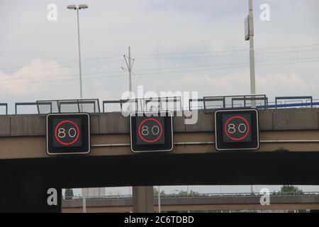 Dynamische Geschwindigkeitsschilder über der Autobahn A20 mit 80 Kilometer als Grenze in Rotterdam in den Niederlanden Stockfoto