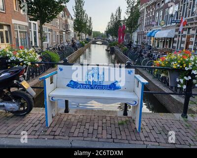 Weiß blaue Bank am Turfmarkt Kanal in der Altstadt der Käsestadt Gouda in den Niederlanden Stockfoto