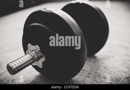 Verstellbare Kurzhantel mit Platte. Schwarzweiß-Foto. Stockfoto