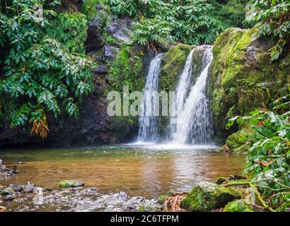 Majestätischer Wasserfall in üppig grünen Wäldern im Naturschutzgebiet Parque Natural da Ribeira dos Caldeiroes in Achada, Nordeste, Sao Miguel, Azoren Stockfoto