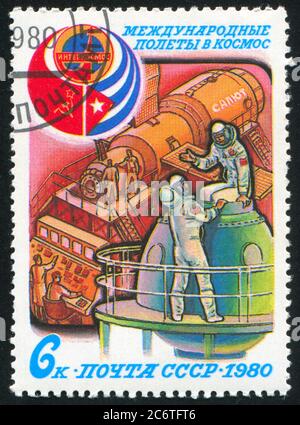 RUSSLAND - UM 1980: Briefmarke gedruckt von Russland, zeigt Interkosmos Emblem, Flaggen der UdSSR und Kuba, und Kosmonauten Ausbildung, um 1980 Stockfoto