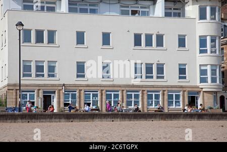 Portobello, Edinburgh, Schottland, Großbritannien 12 Juli 2020.Temperatur 13 Grad am Morgen steigt auf 18 Grad am Nachmittag mit sehr wenig Brise. Einige bevorzugen die Entspannung, einen Kaffee und Snack im Beach House zu genießen, da sie nun einen Außensitzbereich auf der Promenade bieten können. Stockfoto