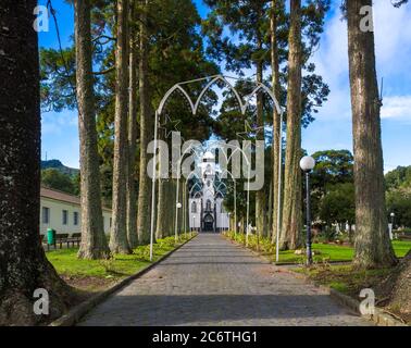 Parkway mit kleiner weißer und grauer Kirche von Sao Nicolau im Dorf Sete Cidades auf der Insel Sao Miguel, Azoren, Portugal Stockfoto