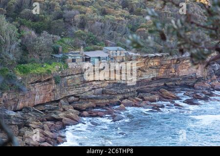 Historische alte Hütten auf einer isolierten Bucht im National Park Buschland von Sydney, Australien Stockfoto