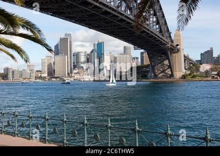 Blick auf die Stadt und den Hafen von Sydney, aufgenommen unter der ikonischen Hafenbrücke auf Wasserhöhe. Stockfoto