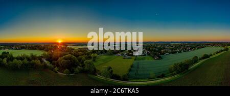 Luftaufnahme eines Wohngebietes in einer ländlichen Stadt in deutschland. Gebäude und Landschaft Hügel Landschaft bei Sonnenuntergang. Stockfoto