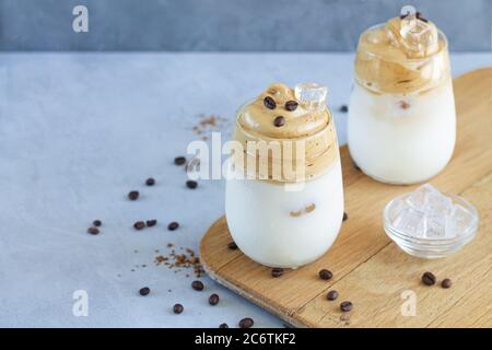 Zwei Gläser kalten Dalgona Kaffee mit Eiswürfeln auf Holzbrett mit Platz für Ihren Text Stockfoto