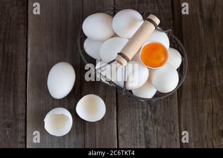 Mesh Metall rustikalen Korb mit weißen Bio-Eier und Orange Eigelb Draufsicht Stockfoto