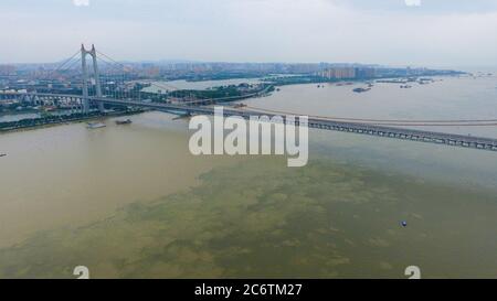 (200712) -- YUEYANG, 12. Juli 2020 (Xinhua) -- Luftfoto vom 12. Juli 2020 zeigt die Brücke des Dongting Sees in der Stadt Yueyang, der zentralchinesischen Provinz Hunan. Das Wasser an einer der hydrologischen Stationen am zweitgrößten Süßwassersee Chinas hat das garantierte Niveau aufgrund von anhaltenden Regenfällen und stromaufwärts gelegenen Zuflüssen überschritten. Am Sonntag gegen 3 Uhr morgens erreichte das Wasser der Chenglingji-Wasserstation des Dongting-Sees in der zentralchinesischen Provinz Hunan 34.56 Meter, 0.01 Meter höher als der garantierte Wert und 2.06 Meter höher als der Warnpegel, so die lokalen Autorinnen Stockfoto