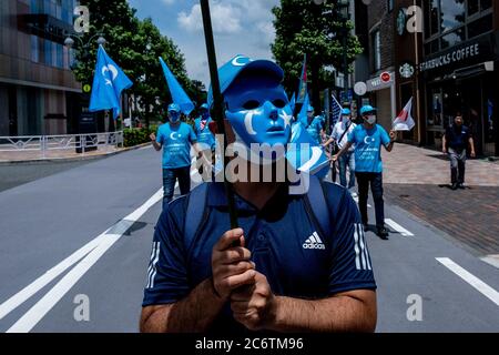 Tokio, Japan. Juli 2020. Ein Protestler, der während des Protestes eine Maske in den Farben der Ostturkestanischen Flagge trug.Demonstranten aus Hongkong und Uiguren gingen in Yoyogi auf die Straße, um die Demokratie zu fördern. Marschieren durch die belebten Straßen Shibuya und Harajuku, um gegen China gegen das neue nationale Sicherheitsgesetz von Hongkong und das Massaker an den Uiguren in der chinesischen Provinz Xinjiang zu protestieren. Kredit: SOPA Images Limited/Alamy Live Nachrichten Stockfoto