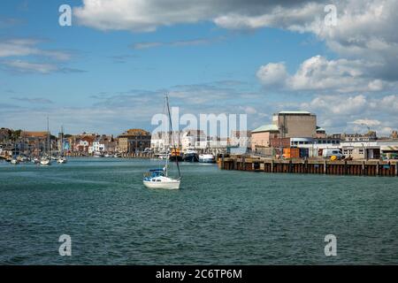 Eine Yacht, die Weymouth Harbour, Weymouth, England, Großbritannien verlässt Stockfoto