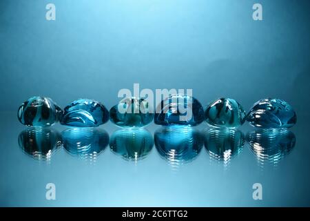 Blaue dekorative Glassteine auf blauem Hintergrund. Stockfoto