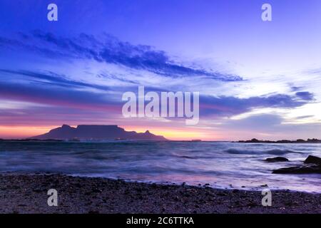 Blick auf den Tafelberg bei Sonnenaufgang, Kapstadt, Südafrika von der Küste des Milnerton Beach Stockfoto
