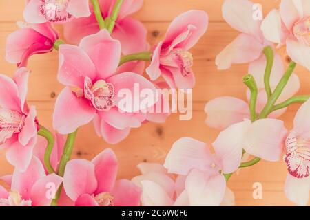 Bündel von künstlichen blühenden Orchideenblumen auf hölzernen Hintergrund. Inneneinrichtung. Stockfoto