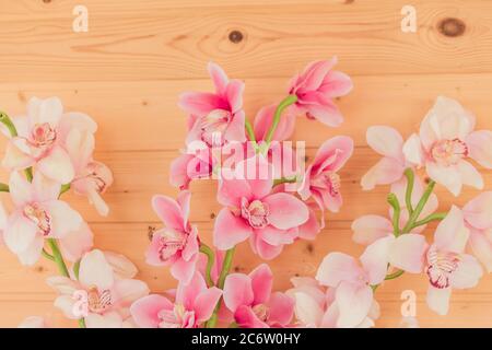 Bündel von künstlichen blühenden Orchideenblumen auf hölzernen Hintergrund. Inneneinrichtung. Stockfoto
