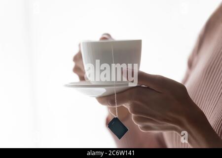 Nahaufnahme der Frau halten trinken heißen Tee in der Tasse Stockfoto