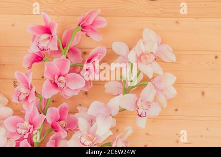 Bündel von künstlichen blühenden Orchideenblumen auf hölzernen Hintergrund. Inneneinrichtung. Stockfoto
