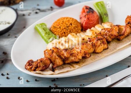 Traditionelles türkisches gegrilltes Hähnchen, Shish Kebab mit Gemüse, das auf Spiessen gegrillt wird Stockfoto
