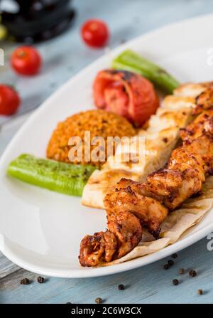 Traditionelles türkisches gegrilltes Hähnchen, Shish Kebab mit Gemüse, das auf Spiessen gegrillt wird Stockfoto