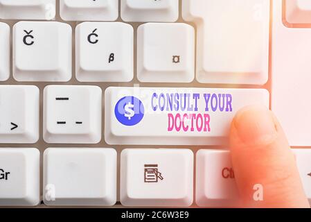 Schreibnotiz zeigt Ihren Arzt konsultieren. Geschäftskonzept für Fragen oder Beratung von einem medizinischen Fachcomputer Tastatur-Taste mit Zeigefine Stockfoto