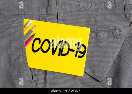 Schreibnotiz mit Covid19. Geschäftskonzept für leichte bis schwere Atemwegserkrankungen, die durch ein Coronavirus-Schreibgerät und gelb nicht verursacht werden Stockfoto