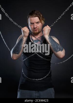 Foto von einem brutalen Mann in Ketten gebunden Stockfoto
