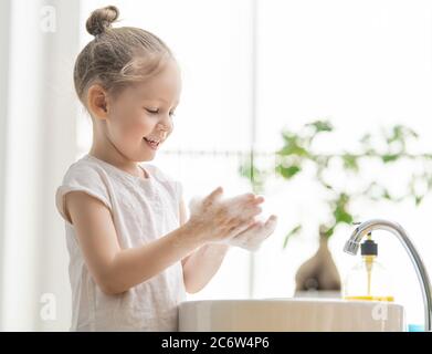 Kleines Mädchen wascht Hände reiben mit Seife. Schutz vor Coronavirus. Prävention, Hygiene zu stoppen Ausbreitung von Viren. Stockfoto