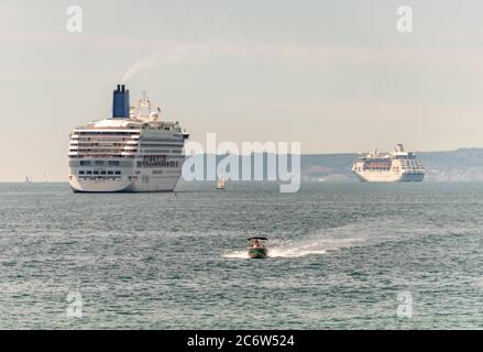 Bournemouth, Großbritannien. Sonntag, 12. Juli 2020. Kreuzfahrtschiffe Aurora und Arcadia liegen vor der Küste in Bournemouth, da sie wegen der Coronavirus-Krise außer Betrieb sind. Quelle: Thomas Faull/Alamy Live News Stockfoto