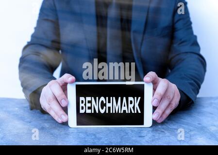 Benchmark für Text in Wort schreiben. Geschäftsfoto mit einem Referenzpunkt, an dem Elemente gemessen oder ausgewertet werden können Modell mit schwarzem Geröll Stockfoto