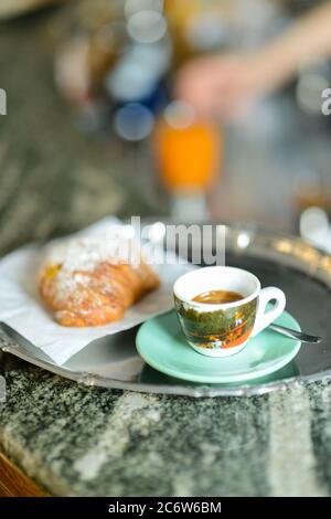 Komplettes italienisches Frühstück mit Espresso-Kaffee, süßem Gebäck gefüllt mit Pudding und Orangensaft Stockfoto