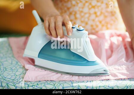 Nahaufnahme auf Frau im Haus in sonnigen Tag Bügeln auf Bügelbrett. Stockfoto