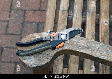 Ein Paar Gartenschere auf einer Gartenbank in Großbritannien, Frühjahr 2020 Stockfoto