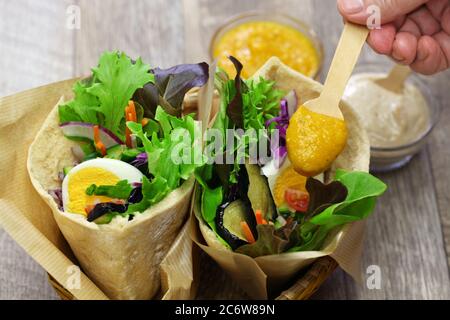 Sabich: israelisches Pita-Sandwich mit gebratener Aubergine, hartgekochtem Ei, israelischem Salat, Amba und Tahini-Sauce Stockfoto