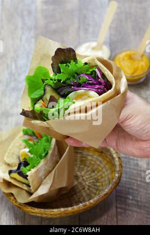 Sabich: israelisches Pita-Sandwich mit gebratener Aubergine, hartgekochtem Ei, israelischem Salat, Amba und Tahini-Sauce Stockfoto