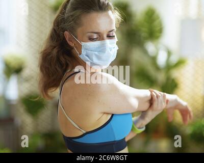 Leben während Coronavirus Pandemie. Fit Frau in Fitness-Kleidung Stretching. Stockfoto