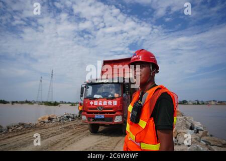 Poyang, Chinas Provinz Jiangxi. Juli 2020. Mitarbeiter arbeiten auf der Baustelle eines durchbrechten Deichs in der Stadt Poyang im Landkreis Poyang, ostchinesische Provinz Jiangxi, 12. Juli 2020. Der Flussufer in der ostchinesischen Provinz Jiangxi wurde am späten Mittwoch nach fortwährenden sintflutartigen Regenfällen durchbrochen, was über 9,000 Einwohner zur Evakuierung zwang. Quelle: Zhou Mi/Xinhua/Alamy Live News Stockfoto