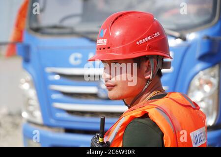 Poyang, Chinas Provinz Jiangxi. Juli 2020. Ein Mitarbeiter arbeitet auf der Baustelle eines durchbrechten Deichs in der Stadt Poyang im Landkreis Poyang, ostchinesische Provinz Jiangxi, 12. Juli 2020. Der Flussufer in der ostchinesischen Provinz Jiangxi wurde am späten Mittwoch nach fortwährenden sintflutartigen Regenfällen durchbrochen, was über 9,000 Einwohner zur Evakuierung zwang. Quelle: Zhang Haobo/Xinhua/Alamy Live News Stockfoto