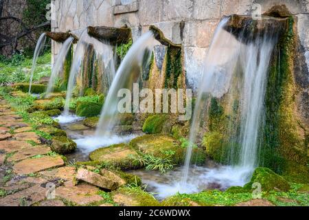 Wasser, das aus der Koubes Quelle im Dorf Kato Melpeia, Nord-West Messinia, Peloponnes, Griechenland, fließt Stockfoto