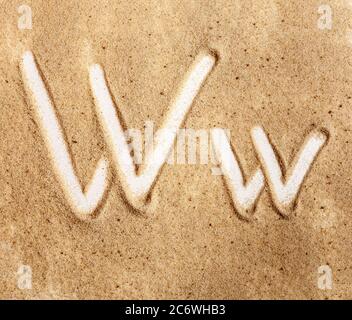 Brief W. Englisches handgeschriebenes Alphabet im Sand. Stockfoto